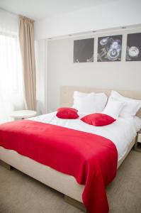 duże czerwono-białe łóżko z czerwonymi poduszkami w obiekcie Potaissa Hotel w mieście Turda