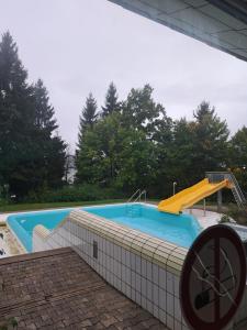 a swimming pool with a slide and a playground at Sternenacht in Sankt Englmar