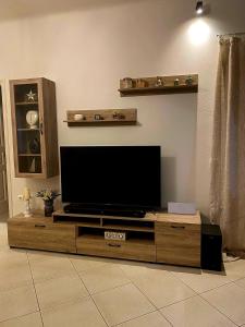 a living room with a flat screen tv on a wooden entertainment center at Deppy's House in Naousa