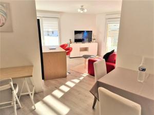 ein Wohnzimmer mit einem roten Sofa und einem Tisch in der Unterkunft l'Etoile du Nord in Romainville