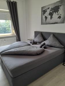 a large bed in a bedroom with a map on the wall at Stylish & Relaxing Modernes Apartment mit Privatparkplatz in Gelsenkirchen