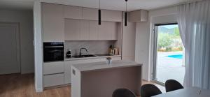 a kitchen with white cabinets and a large window at MB House in Galovac