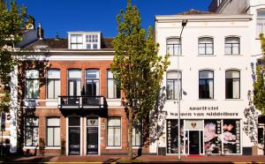 a white building with a sign in front of it at ApartHotel Waepen van Middelburg in Middelburg