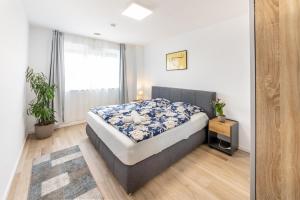 a bedroom with a bed with a blue and white comforter at New & Modern Apartment near Düsseldorf in Willich
