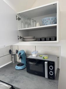 a small kitchen with a microwave in a kitchen at Royal appart city 1 in Calais