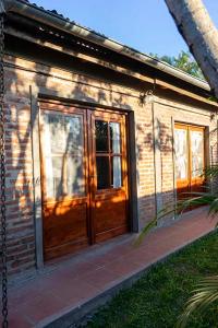 una casa di mattoni con una grande porta di legno di Quincho Don Mario a Bella Vista