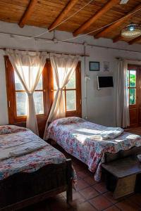 una camera da letto con due letti e due finestre di Quincho Don Mario a Bella Vista
