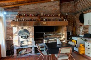 a kitchen with a table and a brick fireplace at Quincho Don Mario in Bella Vista