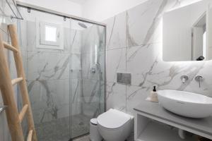 a bathroom with a shower and a toilet and a sink at Delfinaki Boutique Apartments Lionas beach ,Naxos in Lionas +145 photos