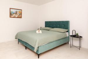 a bedroom with a green bed with two stuffed animals on it at Luxury Grey house in Stolac +22 photos