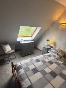 a attic bedroom with a bed and a window at Barfad Self Catering Holiday Cottages in Tarbert