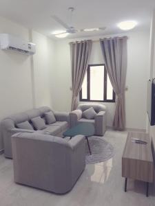 a living room with a couch and a table at Golden Seasons Furnished Apartment 7 in Salalah