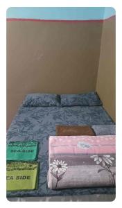 a bed with two boxes on top of it at SeaSide Amour Rendezvous Dormitory BEDS and Airport Shuttles in Korotogo