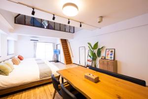 Un dormitorio con una cama y una mesa de madera. en The Uchiyama Toko 博多, en Fukuoka