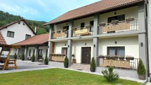 een groot gebouw met balkons en bloemen erop bij Constantin Panzió in Praid