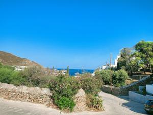 a street with a stone wall and the ocean at Limonletto in Patmos