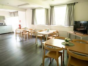 a dining room with tables and chairs and a tv at Motell Fyra Hästar in Rättvik