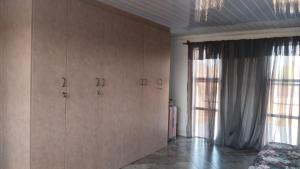 a room with wooden cabinets and a large window at Self service catering cute and comfy nestled in the Center of Lenasia in Lenasia
