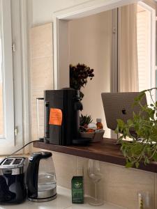 a kitchen counter with a coffee maker on a shelf at Stylish City Stay ,1-Bedroom ,Eiffel Tower Nearby in Vincennes
