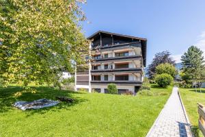 a building on a hill with a grassy yard at Rosels Mountain Lodge Pool Sauna Bergblick Oberaudorf in Oberaudorf