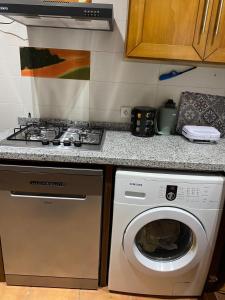 a kitchen with a stove and a washing machine at Cabo garden in Cabo Negro