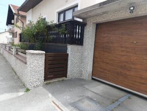 a house with a wooden garage door on the side of it at Gajanka in Bugojno