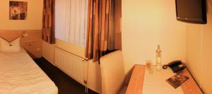 a room with a bed and a table and a television at Achilleon III in Geesthacht