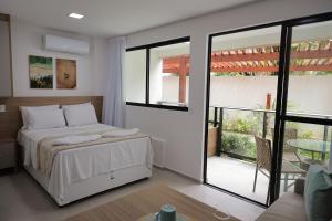 a bedroom with a bed and a sliding glass door at Maré Alta Beach Hall by AFT in Tamandaré +53 photos