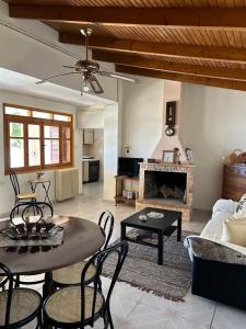 a living room with a table and a fireplace at Ziras Traditional Villa in Áno Váthia +20 photos