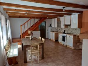 a kitchen and dining room with a table and chairs at Domek v Arnoštově u Pecky  +6 photos