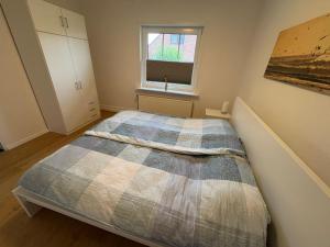 a bedroom with a bed and a window at Ferienhaus Helserdeich - Urlaub zwischen Brunsbüttel und Friedrichskoog in Helse