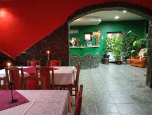 a restaurant with two tables and a green wall at Casa Panaghia in Durău