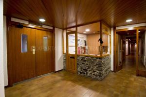 Un pasillo vacío con paneles de madera y una pared de piedra. en Apartarent 1500 - Apartamento Argulls, en Baqueira Beret