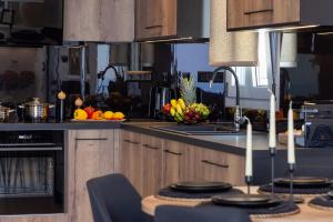 a kitchen with a sink and a bowl of fruit at Tinian Sunset Suite in Istérnia