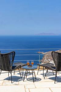 two glasses of wine sitting on a table on a patio at Tinian Sunset Suite in Istérnia