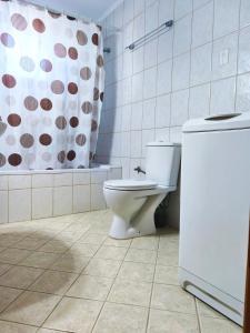 a bathroom with a toilet and a shower curtain at Green Garden Seaside Apartment in Chios +11 photos