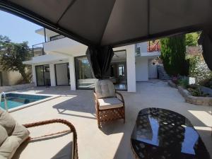 a patio with a table and chairs and a pool at Villa vista mare in Zagrađe