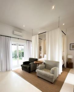 a living room with two chairs and a bed at Huguenot House in Franschhoek