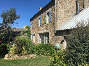 a brick house with a garden in front of it at Chambres Kergana in Landéda