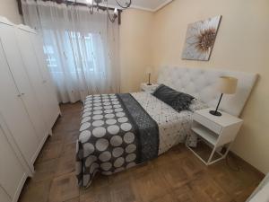 a bedroom with a bed and a table and a lamp at Apartamentos Maliayo B in Villaviciosa