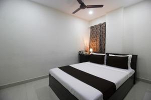 a bedroom with a black and white bed with a ceiling fan at Collection O Stayo in Hyderabad +25 photos