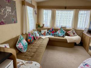 a living room with a couch with pillows at Golden Sands & Winkups in Kinmel Bay