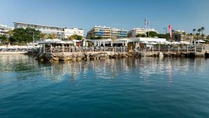 a pier with tables and umbrellas on the water at Royal Antibes - Luxury Hotel, Résidence, Beach & Spa in Antibes +85 photos