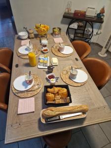 a wooden table with breakfast food on it at Chambre double l'escapade colorée in Rieux-Minervois