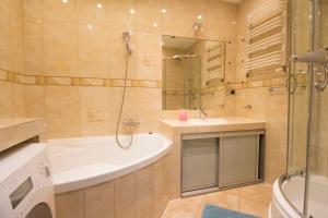 a bathroom with a tub and a sink and a shower at HappyEstate Apartments 3 min do Rynku in Wrocław