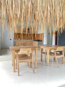 a group of wooden tables and a bench and a piano at Uma Sari Amertha Homestay in Ubud
