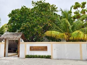a white fence with a gate and a tree at Mirusmaa Inn 