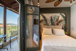 a bedroom with a large bed and a balcony at Nest by the Sea, Nilie Hospitality MGMT in Kala Nera