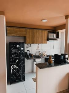 a kitchen with a black refrigerator with drawings on it at Apto Refúgio raiz in Santa Maria