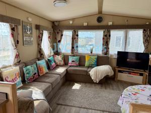 a living room with a couch and a flat screen tv at Golden Sands & Winkups in Kinmel Bay
